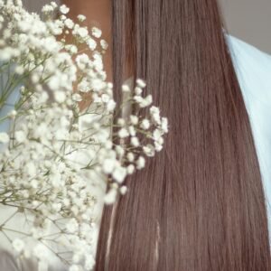 Woman with long brown hair holding white flowers